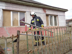 Tűzoltó viszi a létrát az aknához