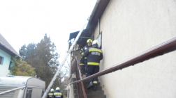 Tűzoltók a ház falánál