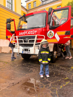 Gyermek a tűtoltóautó előtt