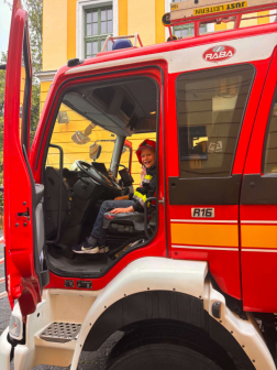 Gyermek ül a tűtoltóautóban