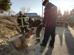 fát darabolnak a földön a tűzoltók