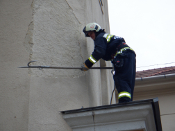 Veszélyes vakolatot bont a tűzoltó