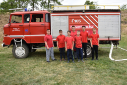 önkéntes csapat a gépjárművük előtt